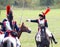 Soldiers-reenactors fight on swords riding horses.