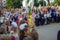 A solemn line of first-graders dedicated to entering the primary school of Minsk, Belarus in the background. Flowers are