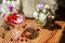 Solemn rustic still life with glass of red drink with autumn berries and ice surrounded by white flowers on textile background.