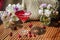 Solemn rustic still life with glass of red drink with autumn berries and ice surrounded by white flowers on wooden table in the
