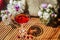 Solemn rustic still life with glass of red drink with autumn berries surrounded by white flowers on textile background on wooden