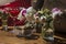 Solemn rustic still life with glass of red drink with cakes in a bowl surrounded by white flowers on textile background on wooden