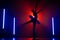 Solhouette of ballerina is practicing elements in studio with neon colorful light. Young woman dancing in classic tutu