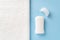 Solid antiperspirant deodorant on a blue background and white bath towel with copy space. Personal hygiene items, body care and