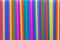 A solid background of many plastic colored straws arranged in row