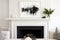 solid, monochrome painting hanging above a white fireplace