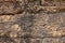 Solid stone wall. Orange bricks closeup. Weathered grungy brick wall photo background. Distressed texture of sandstone.