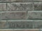 Solid wall with grey bricks in vintage style as grey stonewall background or wallpaper with urban house architecture seamless aged