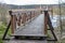 A solid wooden bridge over the forested wetlands. Forest reserve of forest bogs