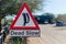 Solitaire, Namibia - July 05 2014: Dead Slow sign with meerkat at dusty desert town Solitaire