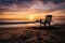 A solitary beach chair facing the ocean at sunrise, inviting relaxation and contemplation