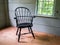 Solitary black chair in an empty room