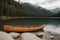 A solitary canoe resting on the banks of a serene lake