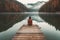 A solitary female traveler contemplates the serene lake, sitting on a wooden dock with a view from behind. Generative AI