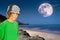 Solitary Figure Gazes at the Moonlit Sky on a Serene Beach