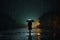 Solitary figure walks in the rain, shielded by a trusty umbrella