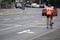 Solitary professional cyclist waits at crosswalk on city street