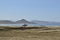 solitary surfer carrying surf board walks along beach on coast Baja Californ