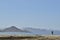 Solitary surfer carrying surf board walks along beach on coast Baja Californ