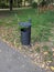 A solitary trash bin standing amidst the green sanctuary of the city park