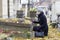 Solitary woman visiting relatives grave.