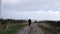 Solitary woman walking through isolated countryside road in Yorkshire England