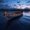 A solitary wooden boat on the calm surface of the lake under the tranquil blue hues of the twilight sky