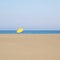 Solitary yellow umbrella on the beach of Cristolu Axedu