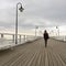 Solitary young woman walking on pier