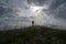 solitude concept of travel active lonely man on grass hill with cloudy sunset on background with copy space during