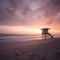 Solitude in Sunrise: A deserted beach and a lone lifeguard tower