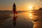 Solitude at sunrise, young woman in white dress strolls on beach