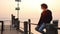 Solitude at Sunset: A Boy Contemplates the Sea from a Pier