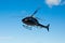 Solo black helicopter in blue skies