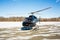 Solo black helicopter in blue skies with snow