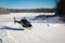 Solo black helicopter in blue skies with snow