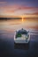 Solo boat on sunset red clouds and sun