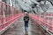 Solo casual woman walking the cycling lane on Williamsburg Bridge, Brooklyn, New York City, USA