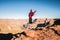 Solo girl traveler spreading her arms and jumping on the edge of a cliff inspired by the scenic view of Grand Canyon West Rim,