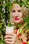 Solo outdoor activities. Portrait of blond woman in red swim suit holding a cup of smoothie.