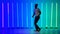 Solo performance by a professional ballroom dancer. Black man dancing salsa against the background of multi-colored neon