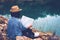 Solo travel in local asia, Back of traveler holding map and sitting on rock ground by lake lagoon, Woman tourist traveler sitting