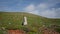 Solo traveler going hill on sunny day. Reflective woman hiking grassy mountain