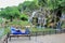 Solo traveling man sitting on the bench with waterfall in the city park background