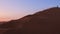 Solo woman stand on top dune enjoy panorama and sunset in Kashan desert