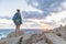 Solo young female traveler watches a beautiful sunset on spectacular rocks of Capo Testa, Sardinia, Italy.