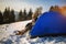 Solo young man traveller camping through an evergreen winter forest in Canada