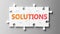 Solutions complex like a puzzle - pictured as word Solutions on a puzzle pieces to show that Solutions can be difficult and needs