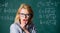 Solve that task. School education basic knowledge. Lady wear eyeglasses smart teacher classroom chalkboard background