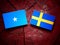 Somalian flag with Swedish flag on a tree stump